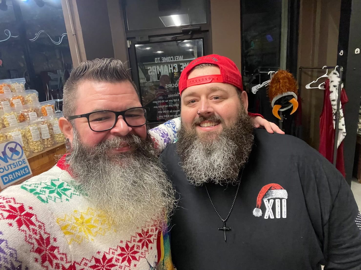 2 bearded villains hugging by the shoulder at a Christmas party